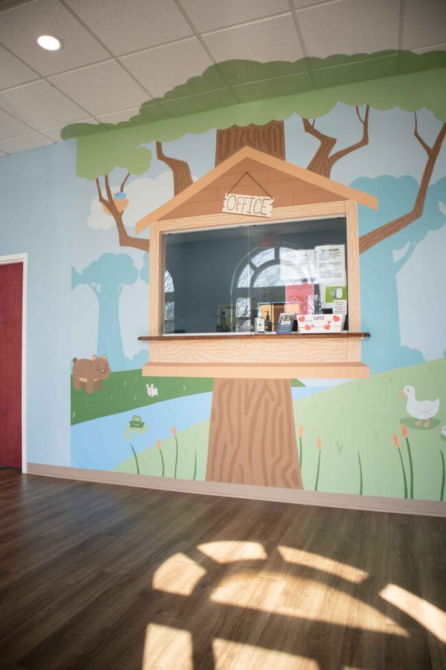 Kid's Creek Therapy - A graphic of a big tree in the forest decorate the walls of the Kid's Creek office