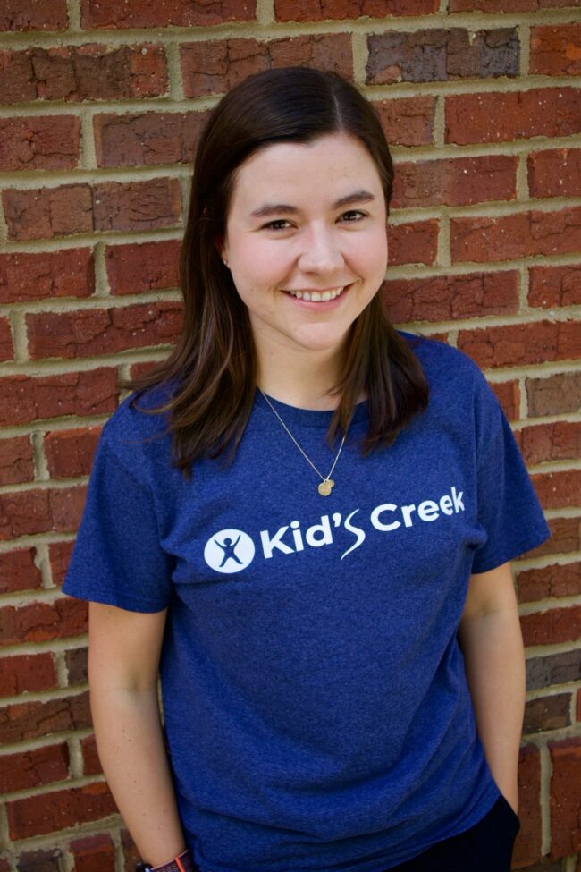Leah Kid's Creek Therapy - Employee poses for headshot with brick wall in background