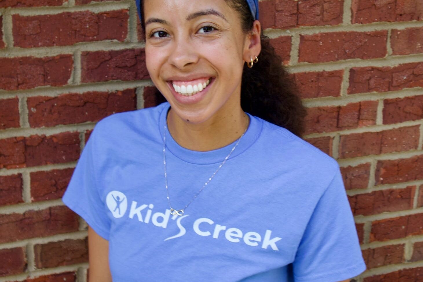Kid's Creek Therapy - Employee poses for headshot with brick wall in background