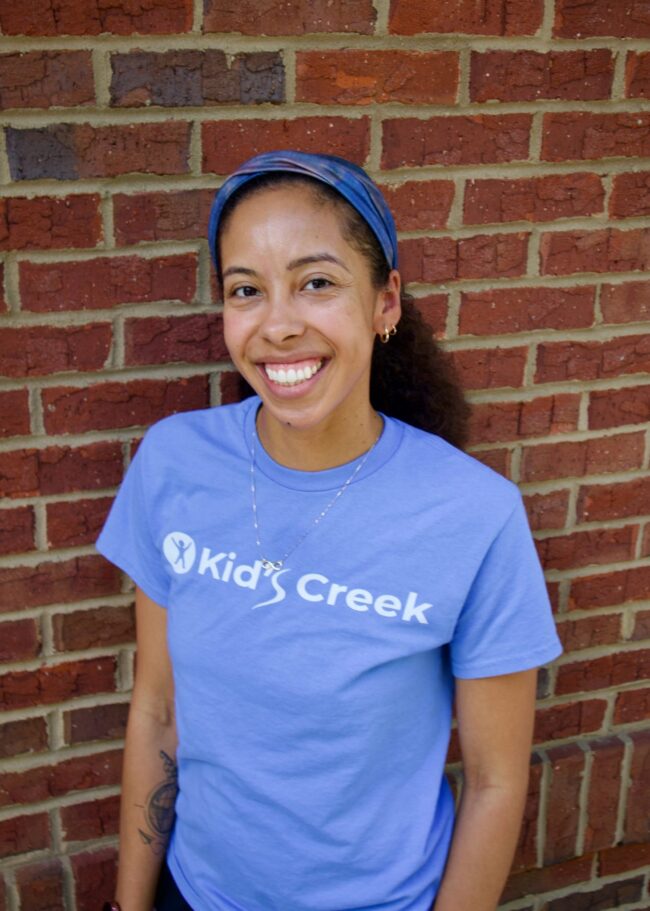 Priscilla Kid's Creek Therapy - Employee poses for headshot with brick wall in background