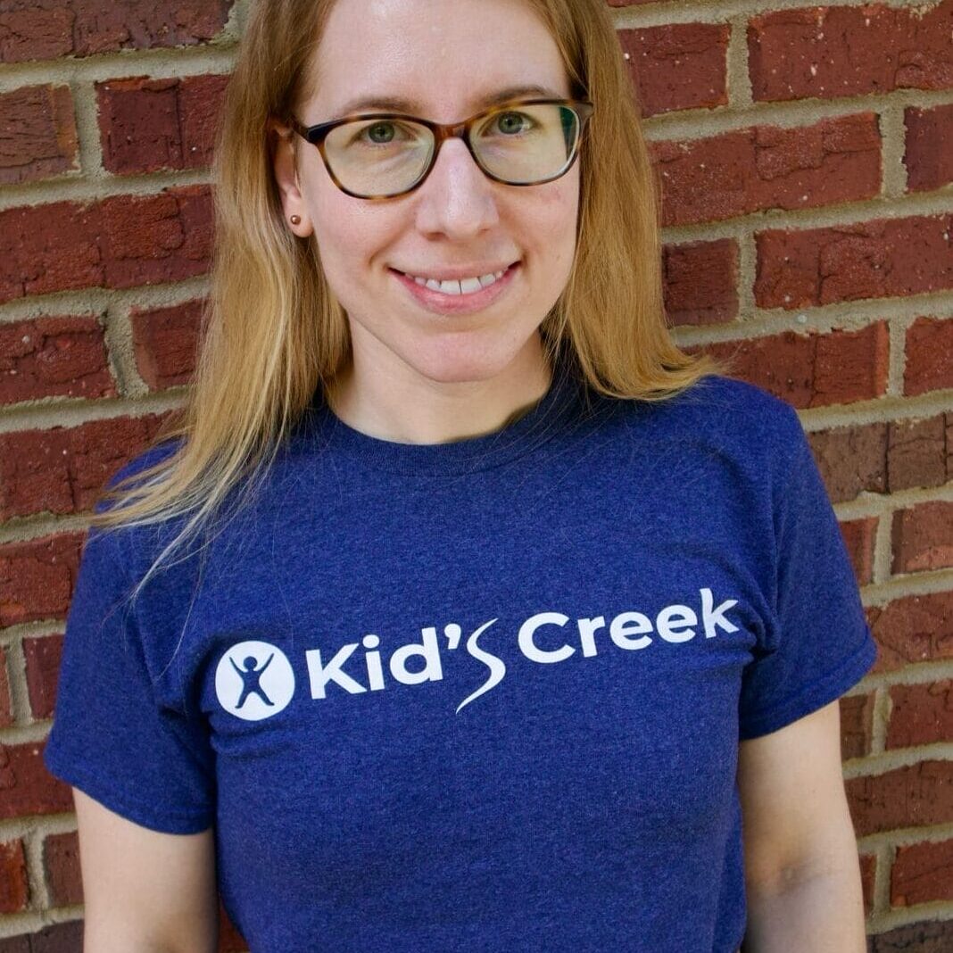 Emily Kid's Creek Therapy - Employee poses for headshot with brick wall in background