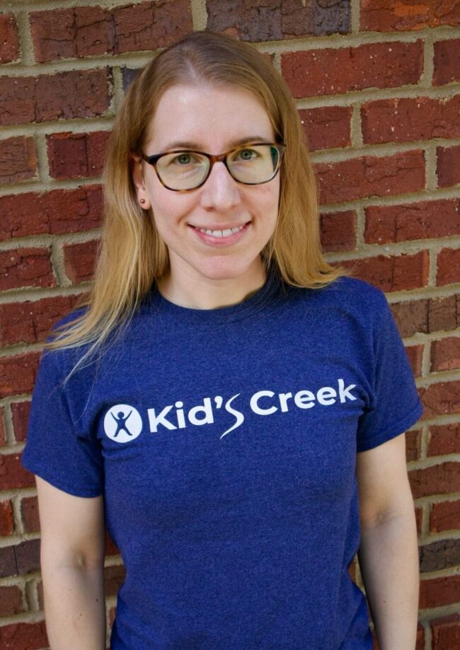 Emily Kid's Creek Therapy - Employee poses for headshot with brick wall in background