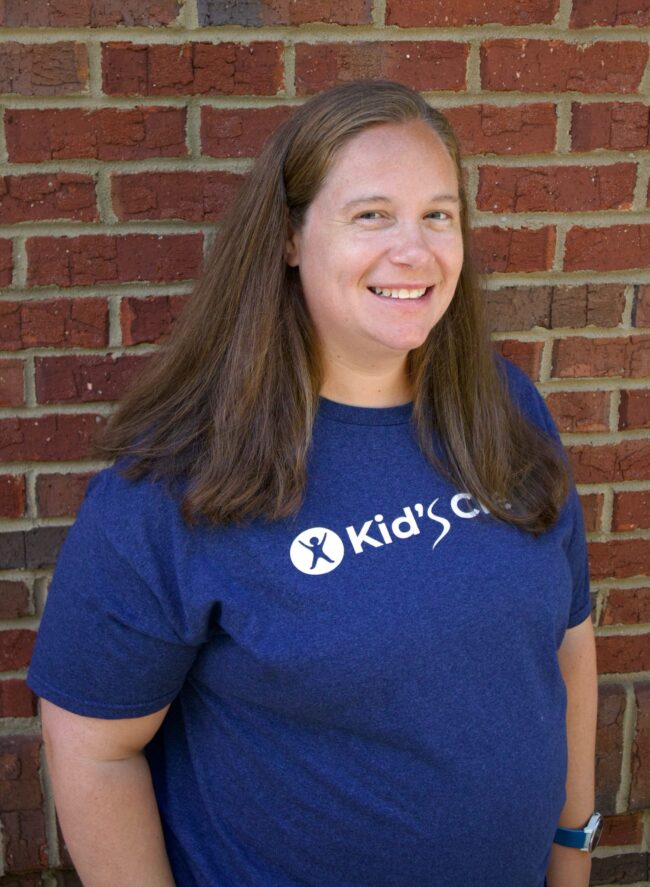Amy Kid's Creek Therapy - Employee poses for headshot with brick wall in background