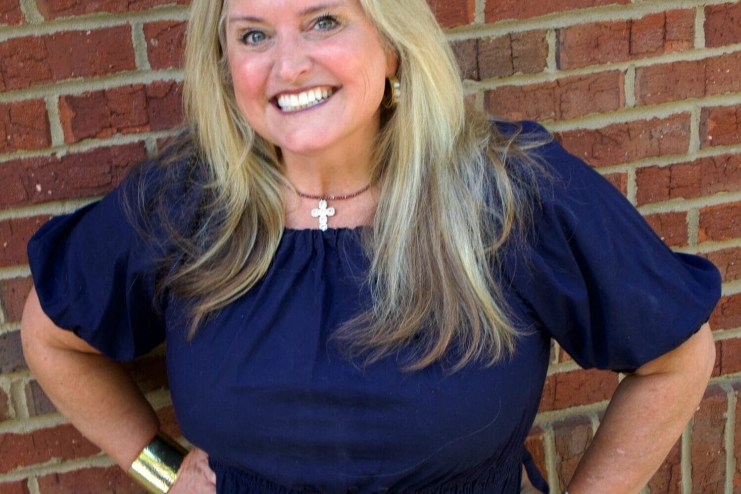Kid's Creek Therapy - Employee poses for headshot with brick wall in background