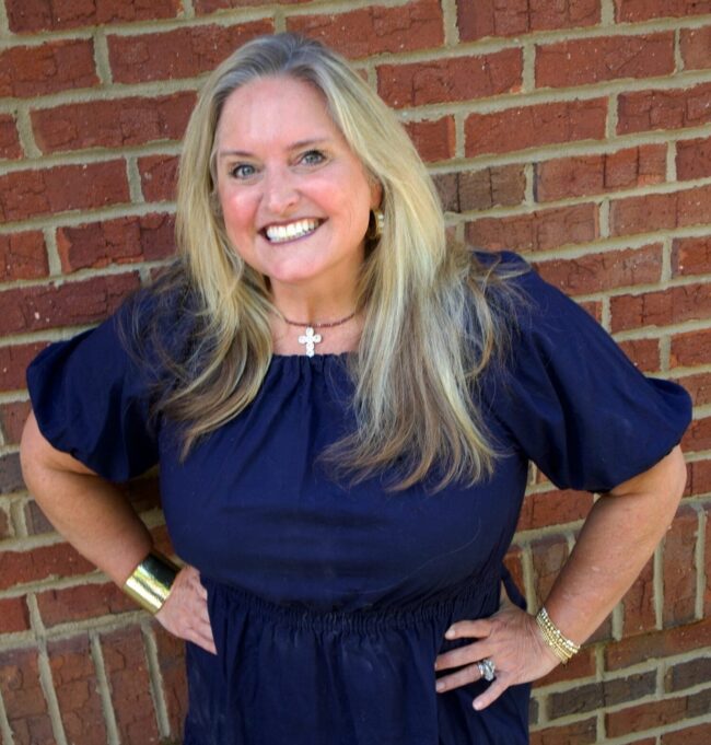 Heather Kid's Creek Therapy - Employee poses for headshot with brick wall in background
