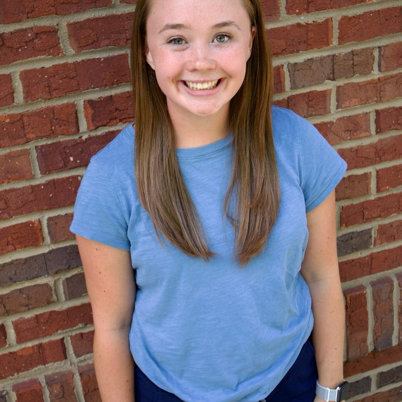Kid's Creek Therapy - Employee poses for headshot with brick wall in background