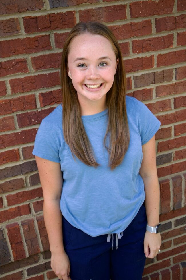 Amber Kid's Creek Therapy - Employee poses for headshot with brick wall in background