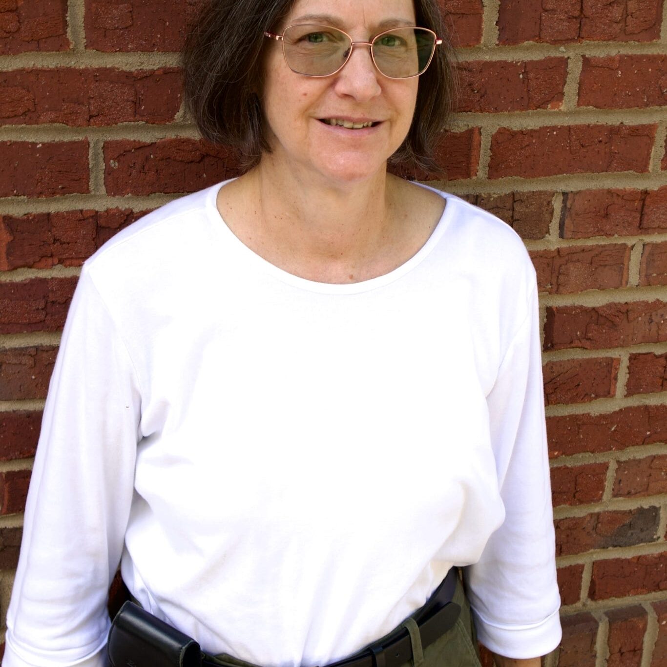 Kid's Creek Therapy - Employee poses for headshot with brick wall in background