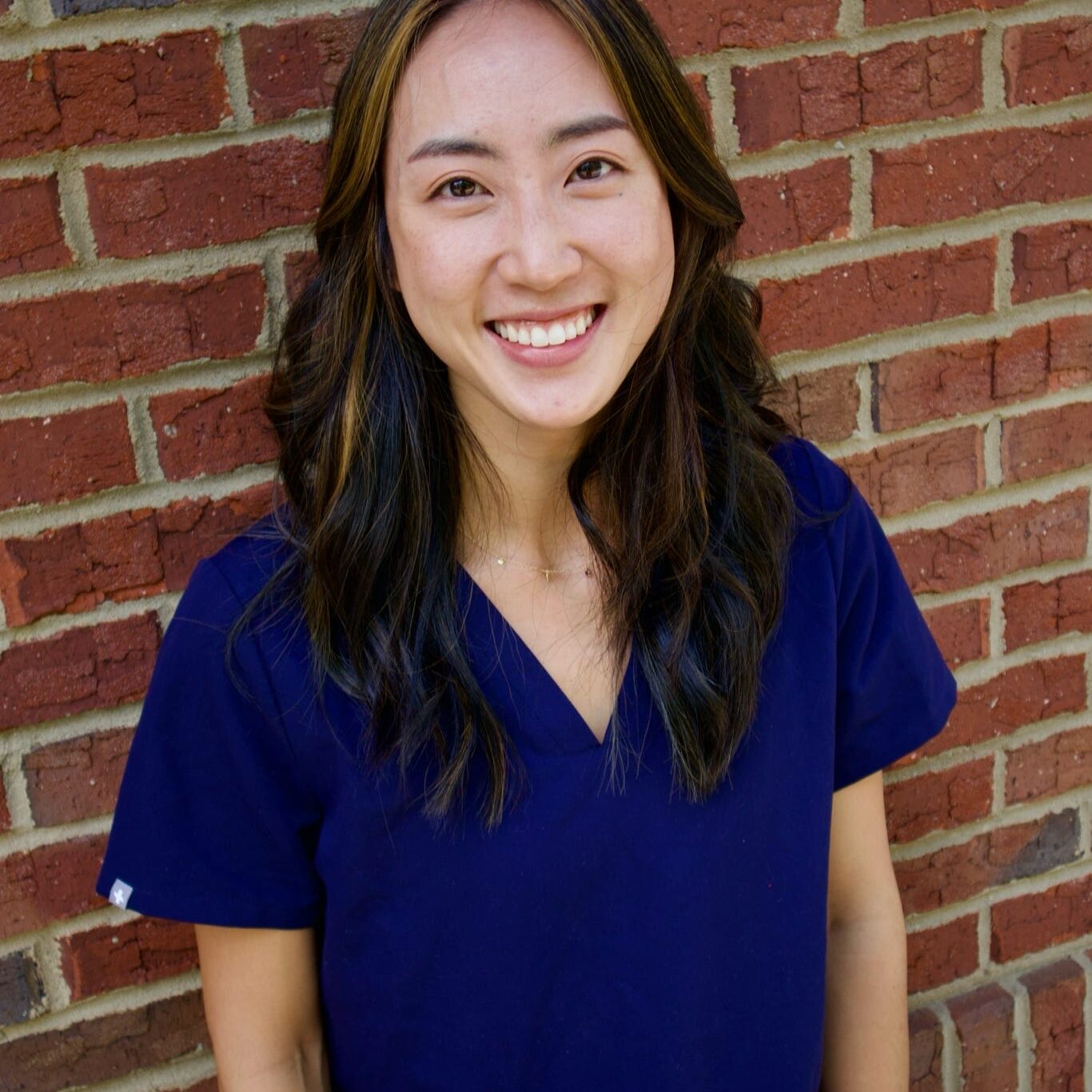 Kid's Creek Therapy - Employee poses for headshot with brick wall in background