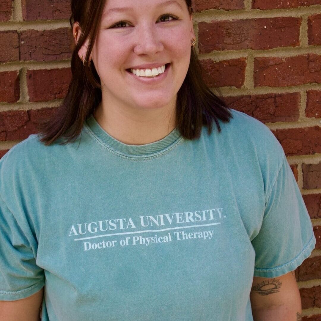 Kid's Creek Therapy - Employee poses for headshot with brick wall in background