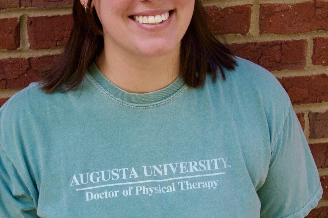 Kid's Creek Therapy - Employee poses for headshot with brick wall in background