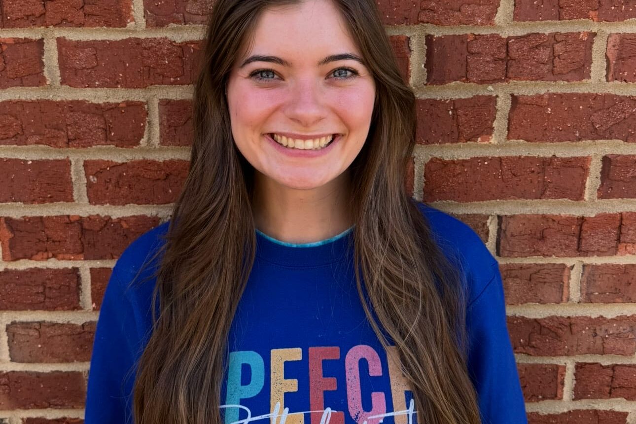 Kid's Creek Therapy - Employee poses for headshot with brick wall in background