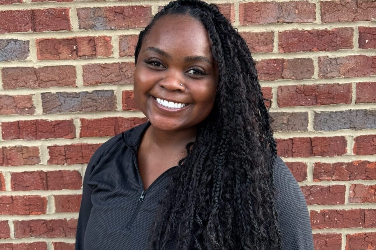 Kid's Creek Therapy - Employee poses for headshot with brick wall in background