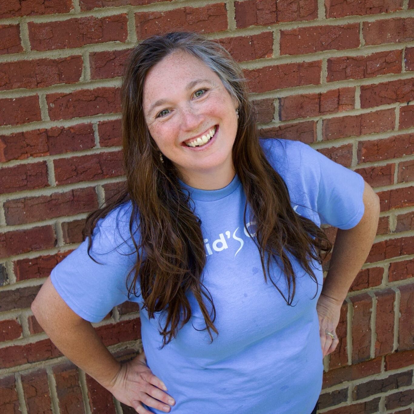 Kid's Creek Therapy - Employee poses for headshot with brick wall in background